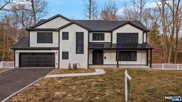 view of front of home featuring aphalt driveway, a porch, an attached garage, metal roof, and fence