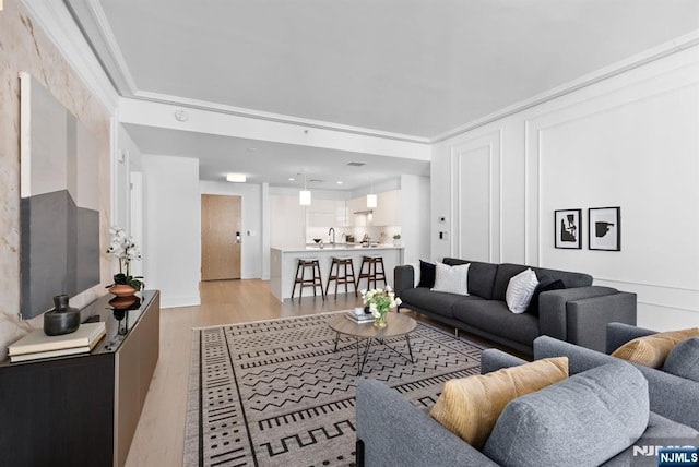 living room featuring light wood-style flooring and crown molding