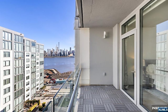 balcony featuring a water view and a city view