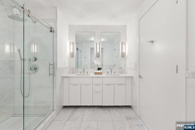 bathroom with a sink, double vanity, and a shower stall