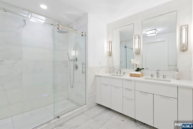 full bath with double vanity, a sink, and a shower stall