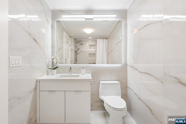 full bath featuring tile walls, a shower with shower curtain, vanity, and toilet