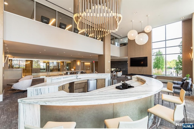 kitchen featuring a towering ceiling, open floor plan, and a sink