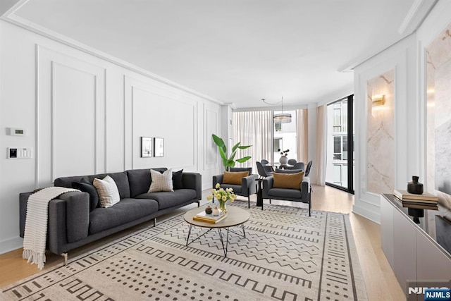 living room with a decorative wall and wood finished floors