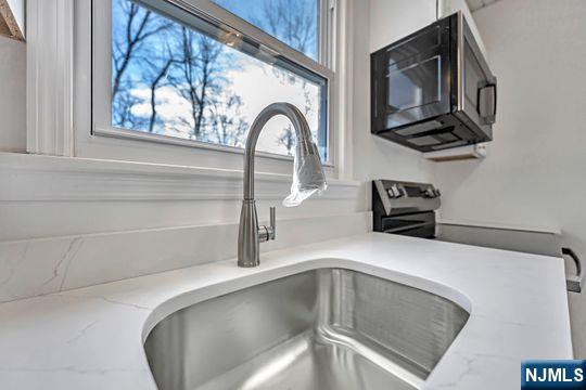 details with light stone counters and a sink