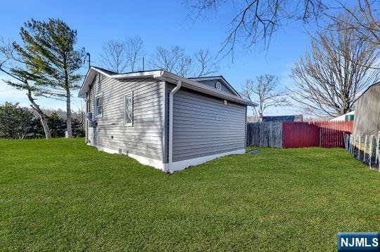 view of property exterior featuring a yard and fence