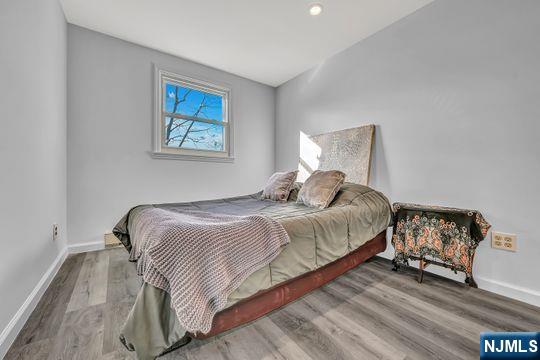 bedroom with baseboards and wood finished floors