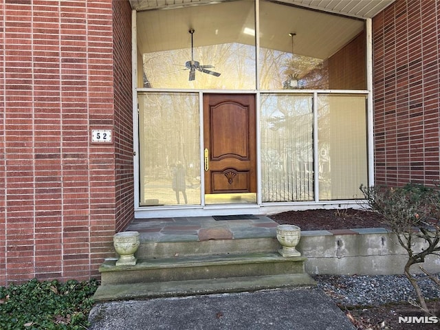 view of exterior entry featuring brick siding