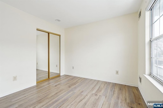 unfurnished room featuring wood finished floors and baseboards