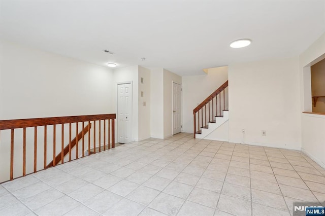 empty room with visible vents, stairway, and tile patterned floors