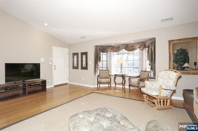 living area featuring recessed lighting, visible vents, vaulted ceiling, wood finished floors, and baseboards