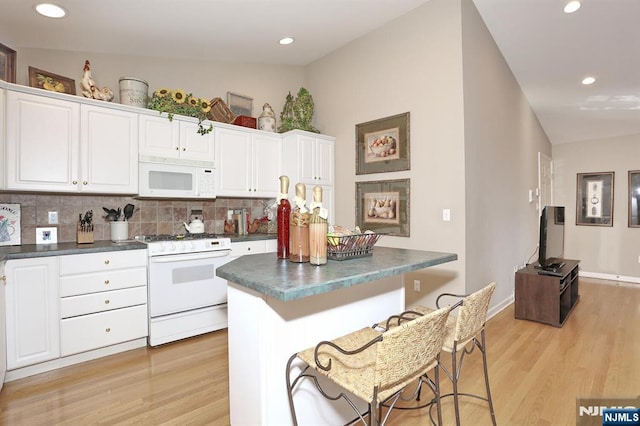 kitchen with light wood-type flooring, dark countertops, white appliances, and decorative backsplash