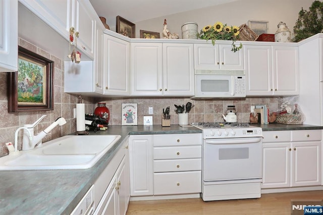 kitchen with white cabinets, white appliances, decorative backsplash, and a sink