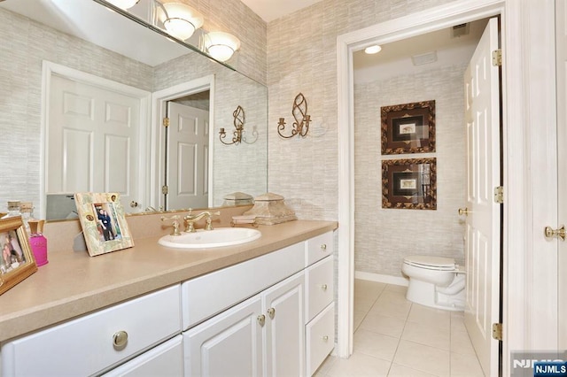 bathroom with toilet, vanity, visible vents, and tile patterned floors