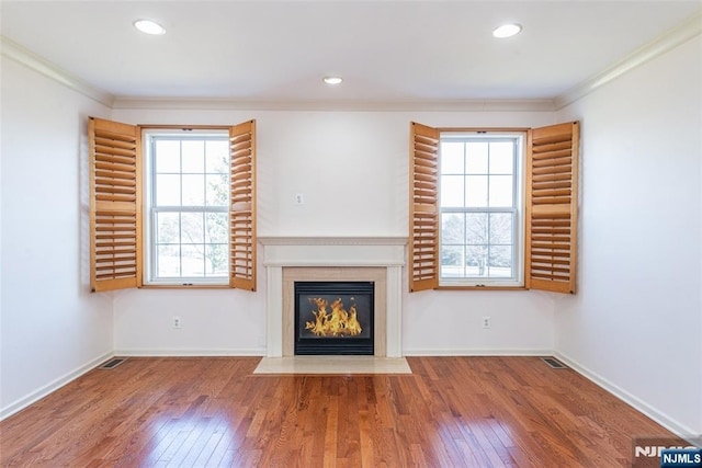 unfurnished living room with ornamental molding, a fireplace with flush hearth, hardwood / wood-style flooring, and baseboards