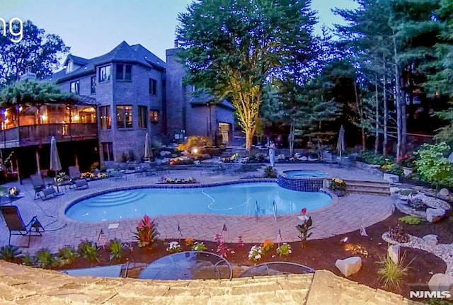 view of pool with a pool with connected hot tub and a patio