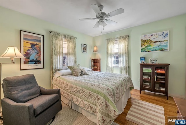 bedroom featuring ceiling fan, wood finished floors, and baseboards