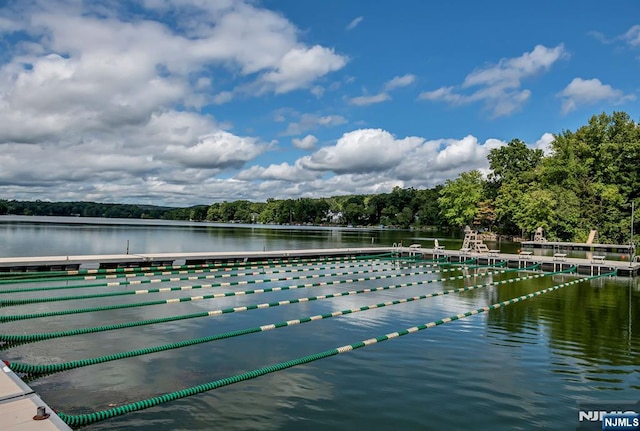 view of swimming pool with a water view and a boat dock