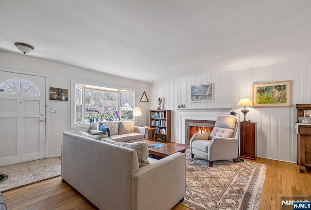 living room featuring light wood finished floors and a fireplace with flush hearth