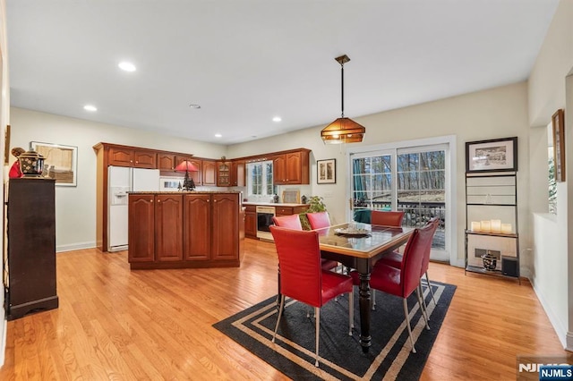 dining room with light wood finished floors, baseboards, and recessed lighting