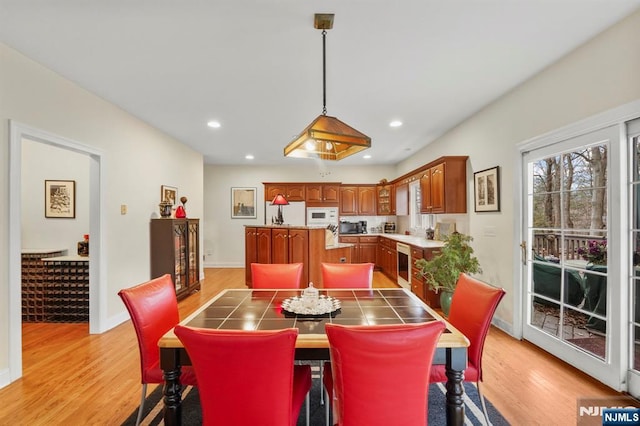 dining area featuring light wood-style flooring, baseboards, beverage cooler, and recessed lighting