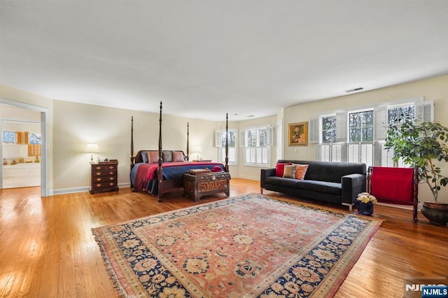 bedroom with light wood-type flooring, visible vents, and baseboards