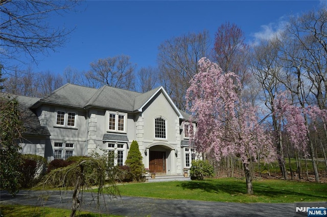 view of front of home with a front yard and stucco siding