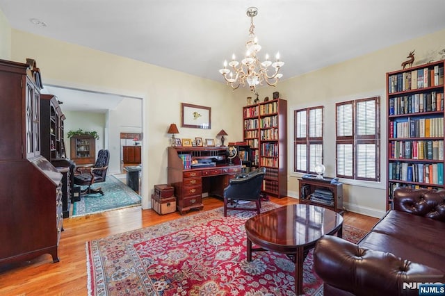 home office featuring light wood-style floors, a chandelier, and baseboards