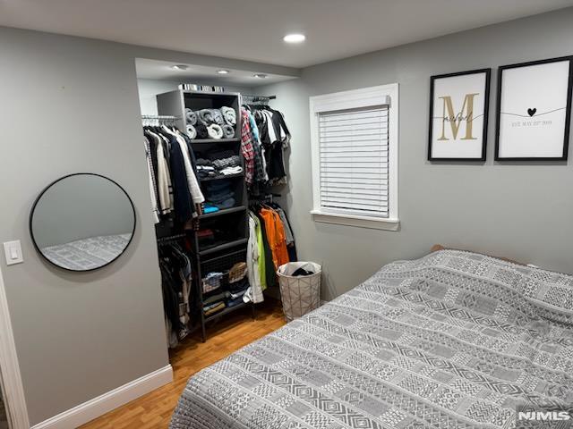 bedroom with light wood-style floors, recessed lighting, and baseboards