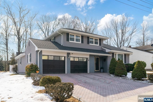 view of front of property featuring roof with shingles, decorative driveway, and brick siding