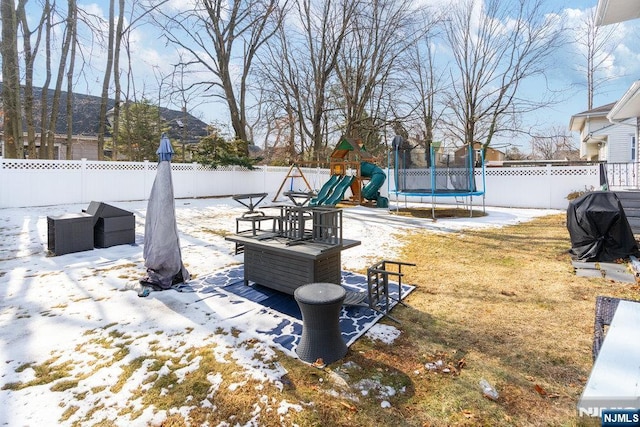 view of yard featuring a trampoline, a fenced backyard, and a playground