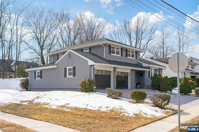 view of front of home featuring aphalt driveway, fence, and an attached garage