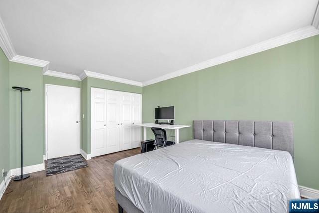 bedroom with crown molding, baseboards, and wood finished floors