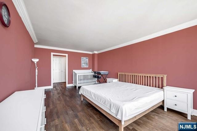 bedroom with ornamental molding, dark wood finished floors, and baseboards