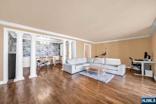 living room featuring baseboards, ornamental molding, wood finished floors, and ornate columns