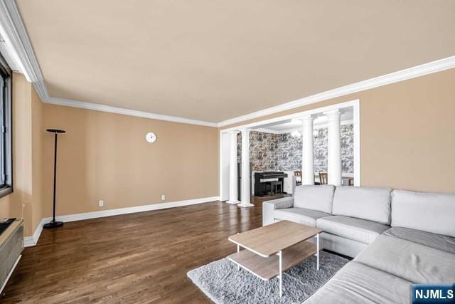 living room with baseboards, decorative columns, ornamental molding, and wood finished floors