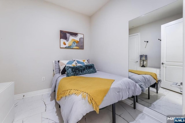 bedroom with baseboards and marble finish floor