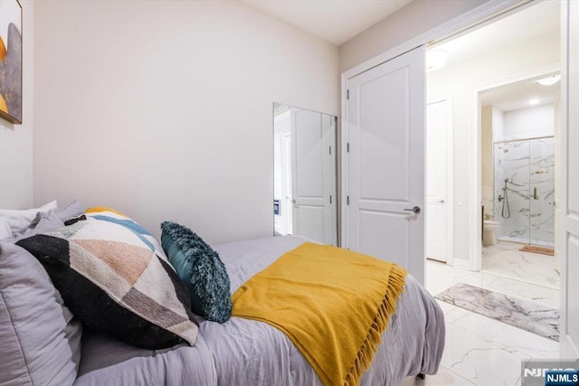 bedroom featuring a closet, marble finish floor, and connected bathroom