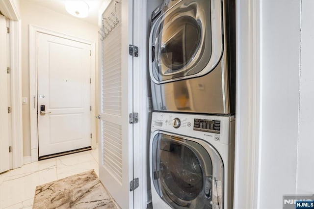 washroom with laundry area, stacked washer / drying machine, and marble finish floor