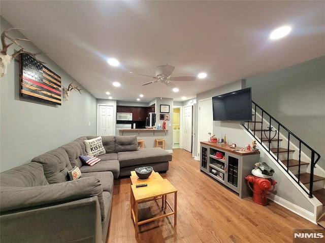 living area with light wood-style floors, stairs, a ceiling fan, and recessed lighting