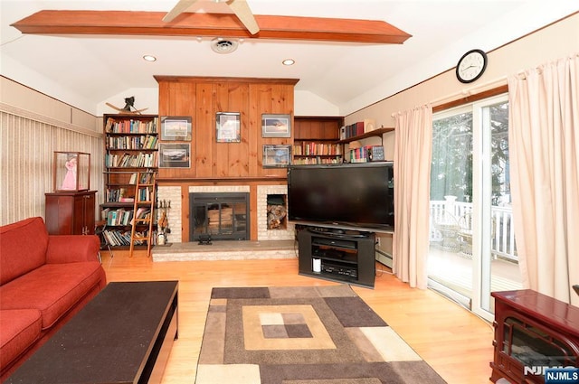 living area with lofted ceiling, a brick fireplace, and wood finished floors