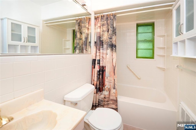 bathroom with tile walls, visible vents, toilet, shower / bath combo, and vanity