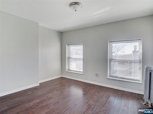 5 Elm St, Newark, NJ 07102 - spare room featuring radiator heating unit, dark wood-style flooring, and baseboards