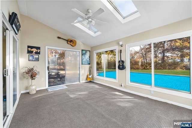 unfurnished sunroom featuring vaulted ceiling with skylight and ceiling fan