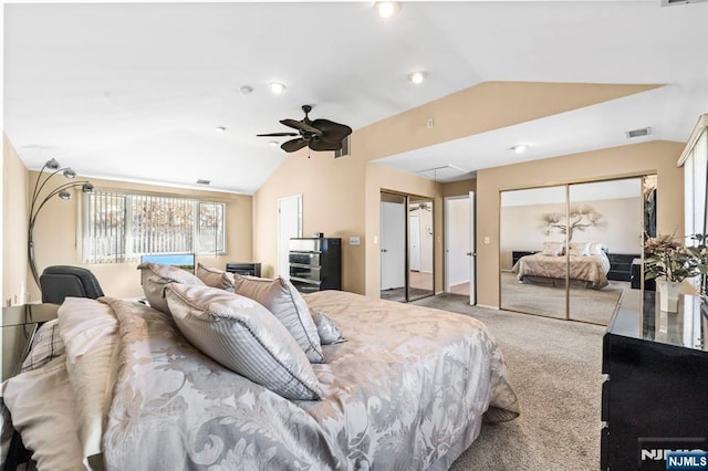 bedroom with vaulted ceiling, carpet floors, two closets, and visible vents