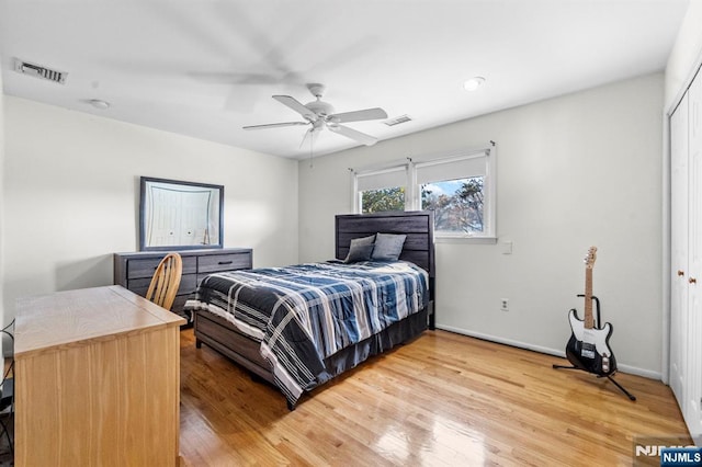 bedroom with a closet, visible vents, light wood-style flooring, and baseboards