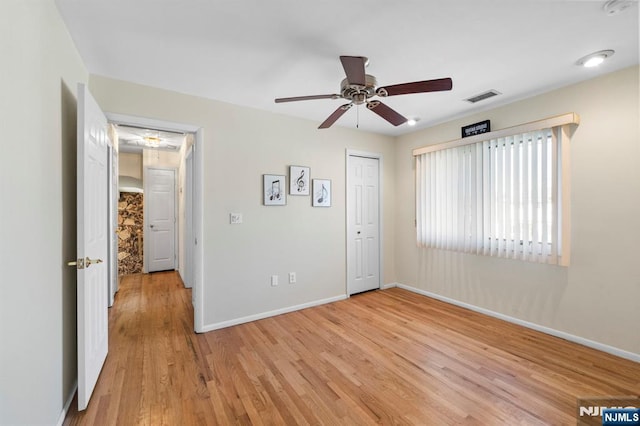 interior space featuring light wood-type flooring, baseboards, visible vents, and ceiling fan