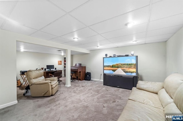 carpeted living room with a drop ceiling and baseboards