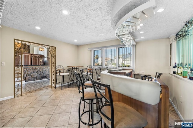 kitchen featuring tile patterned flooring, baseboards, a textured ceiling, and recessed lighting