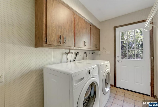 washroom with washing machine and clothes dryer, light tile patterned floors, and cabinet space